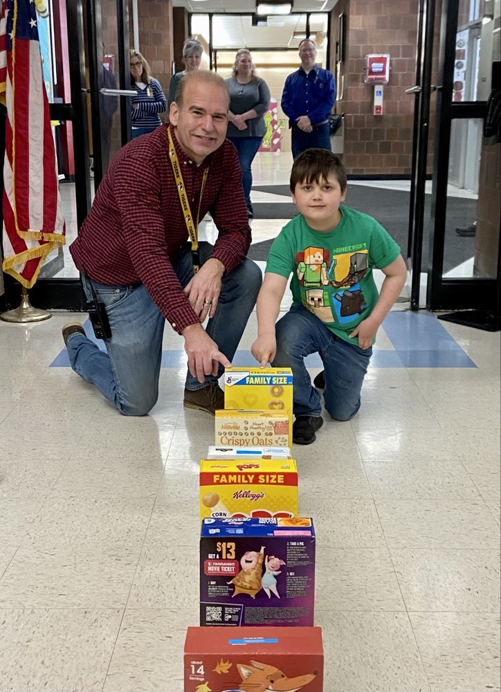 Principal and student with cereal box